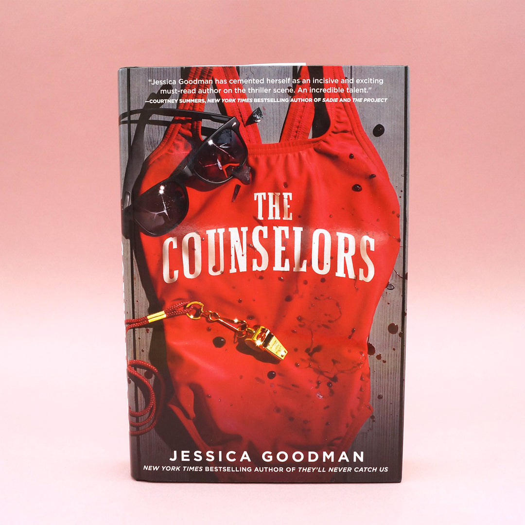 A hardcover copy of The Counselors by Jessica Goodman on a pink background.