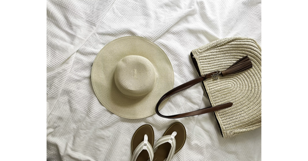 Summer essentials including a straw hat, woven beach bag and sandals, perfect for packing a bookish day in the sunshine.