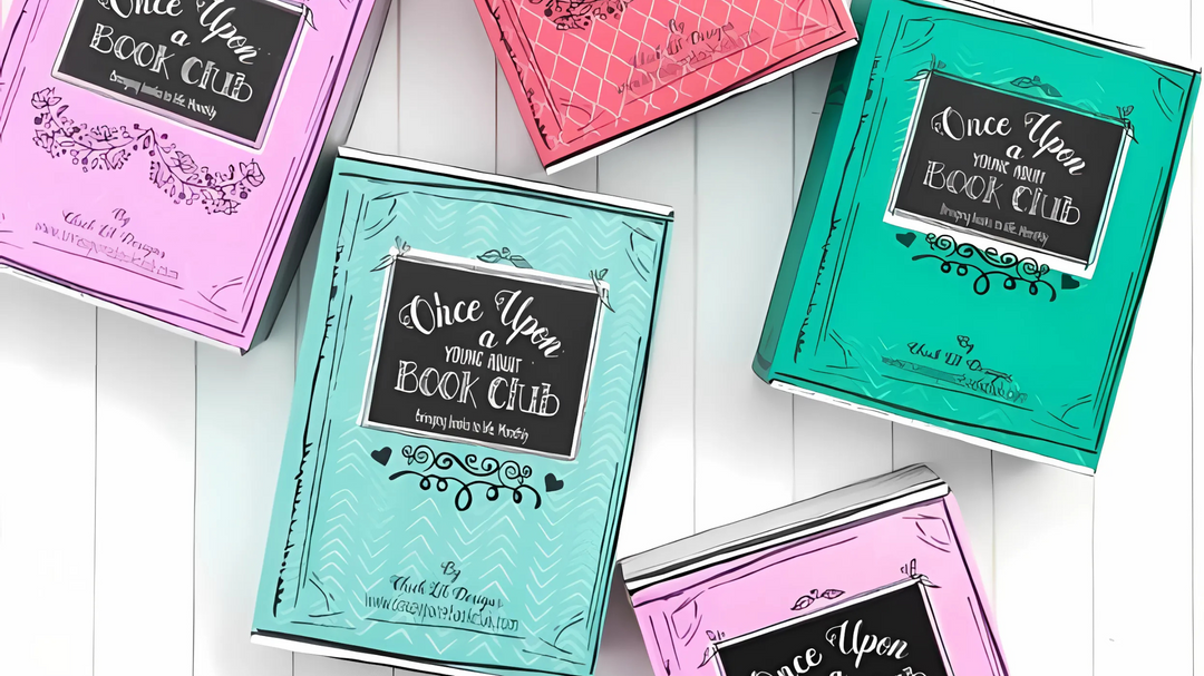 Colorful Once Upon a Book Club boxes in pink, teal, and green arranged on a white wooden surface.