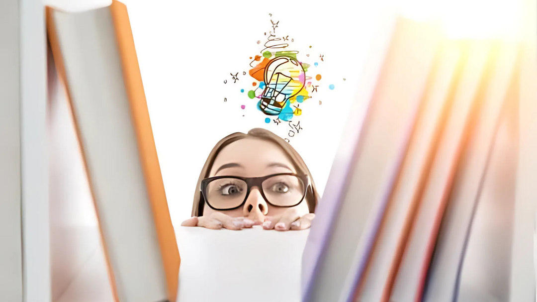 A young woman peering through the books arranged on a bookshelf. 