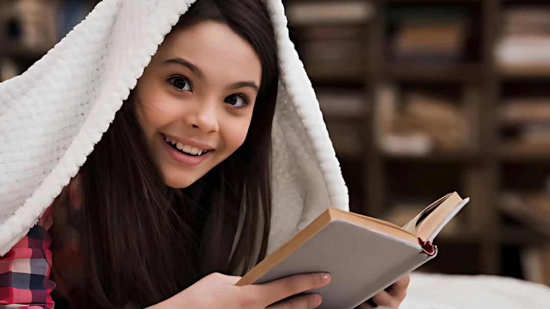 A young girl smiling while reading a book under a cozy blanket, surrounded by a warm and inviting library setting.