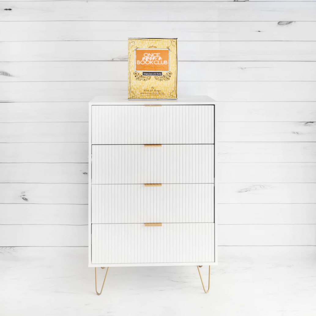 A book box with 'Once Upon a Book Club' written on the front is placed on top of a white cupboard.