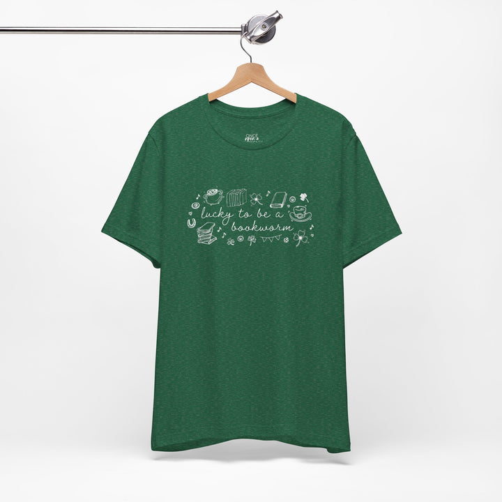 Green t-shirt with white font reading "lucky to be a bookworm" and line illustrations of St. Patrick's Day items and books on a white background
