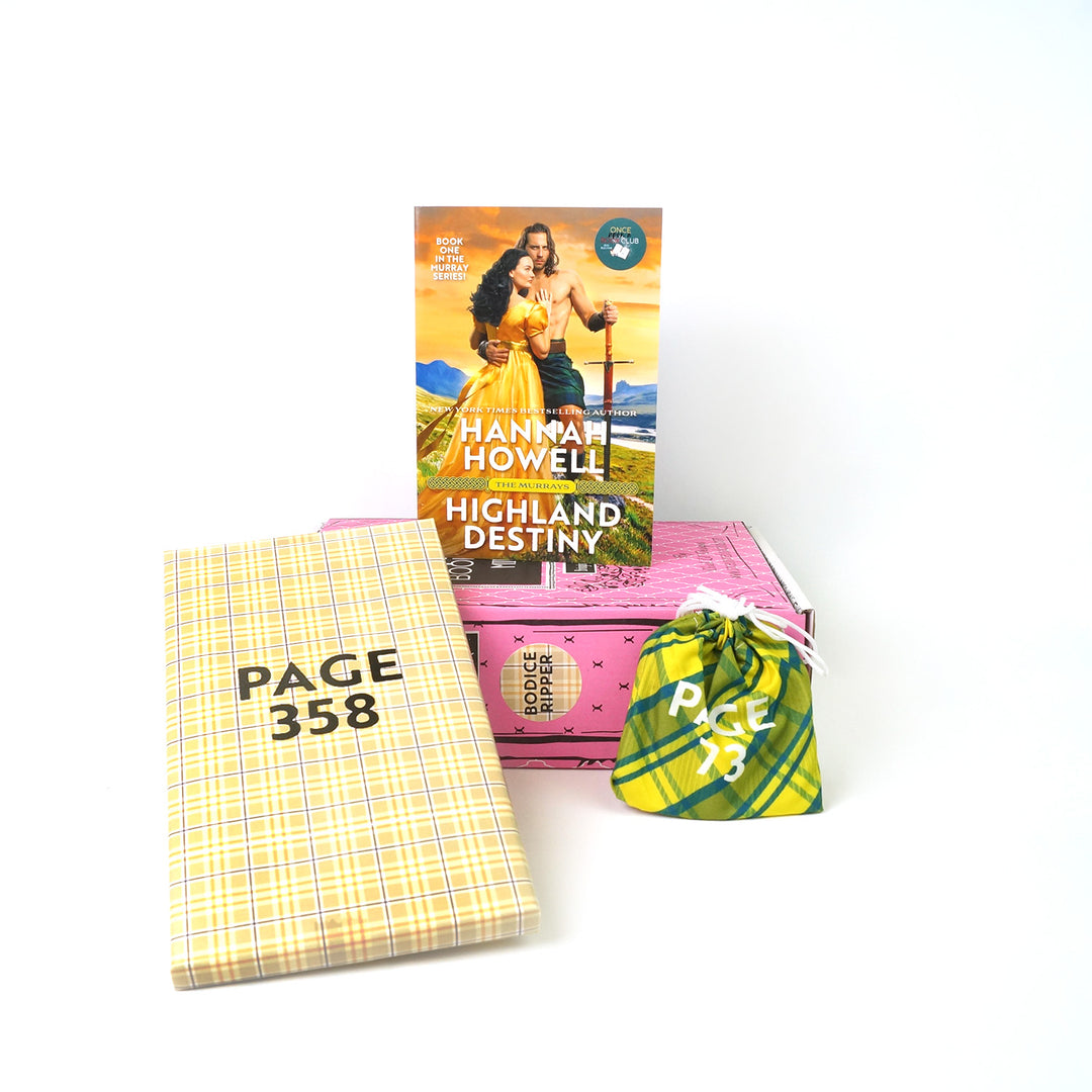 A mass market paperback edition of Highland Destiny by Hannah Howell sits on a pink book box surrounded by two wrapped gifts labeled with page numbers.