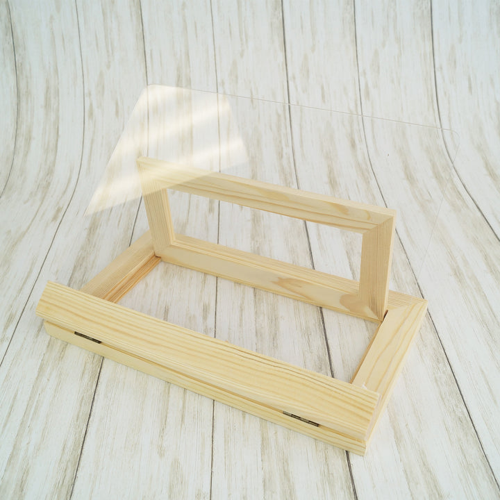 a light wood and plexiglass bookstand unfolded to show it empty.