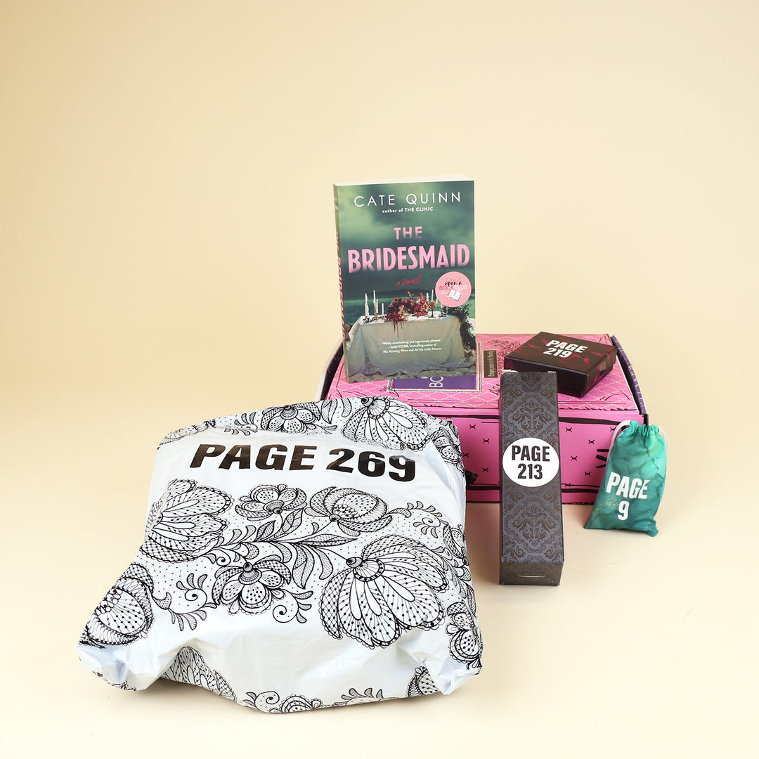 A paperback edition of The Bridesmaid stands on a pink OUABC box next to a small box labeled with a page number. In front of the box are three wrapped gifts labeled with page numbers.