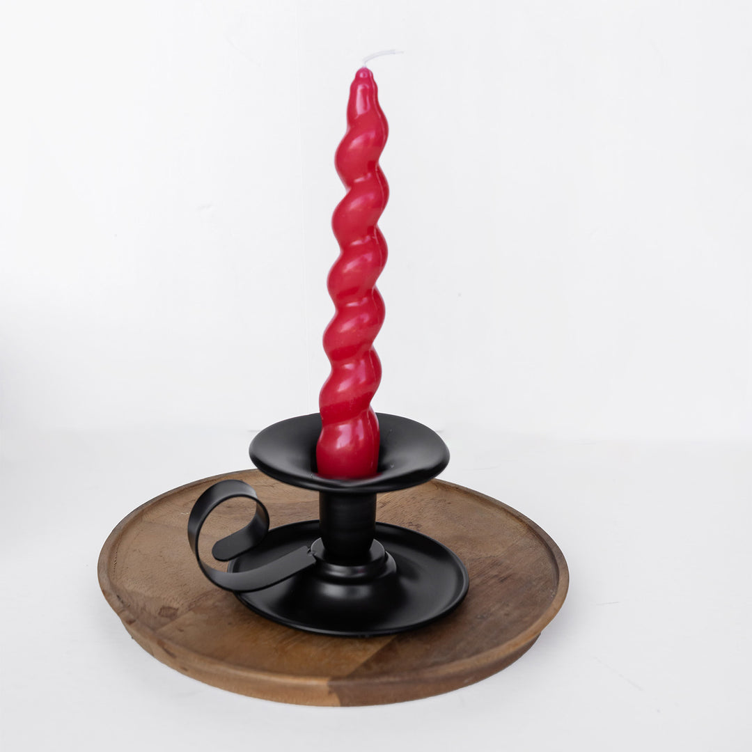 Red twisted candle in a black holder