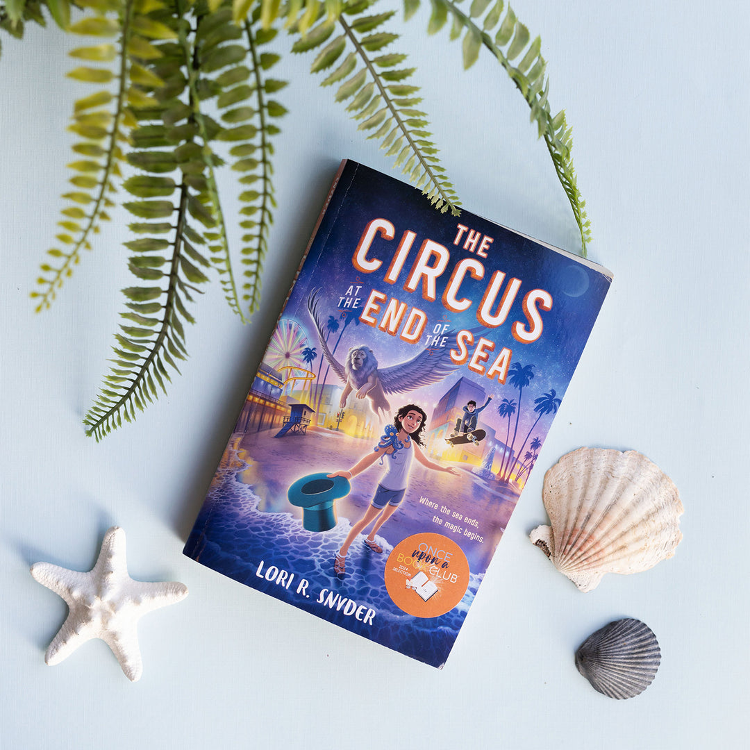 a paperback copy of The Circus at the End of the Sea by Lori R. Snyder