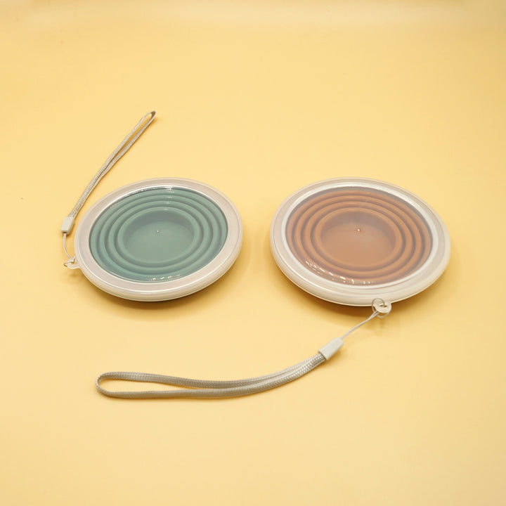 a pair of collapsible cups sit next to each other on a yellow background, collapsed