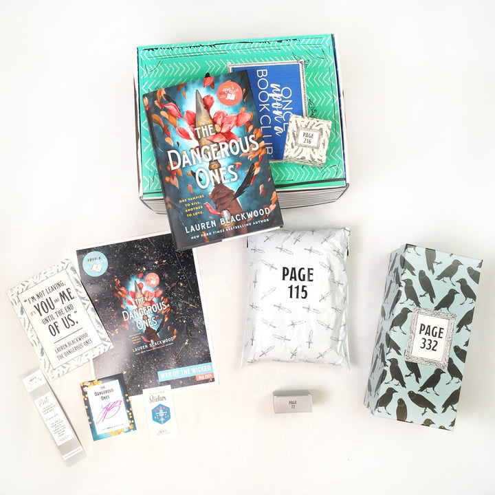 A hardcover copy of The Dangerous Ones by Lauren Blackwood sits on a green Once Upon a Book Club young adult box. This box is surrounded by wrapped gifts labeled with page numbers in addition to paperwork including a signed bookplate from the author, bookmark, art print, and matching collectible sticker.