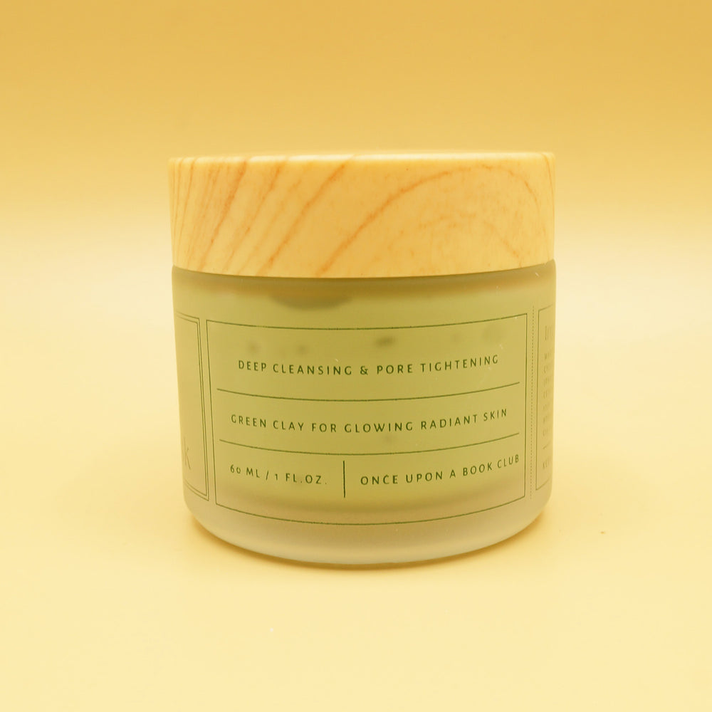 a green clay face mask in a container with a wooden lid