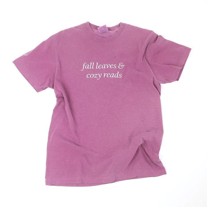 A heathered mauve-purple short-sleeve t-shirt with the phrase 'fall leaves & cozy reads' printed in white script across the chest, laid flat on a white background.