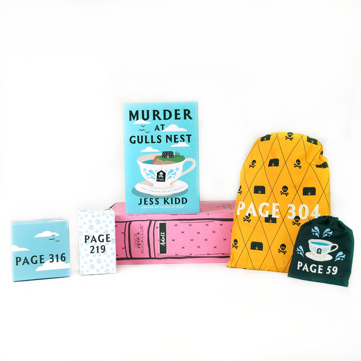 An exclusive edition of Murder at Gull's Nest by Jess Kidd on a pink OUABC box surrounded by wrapped gifts.