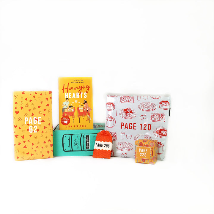 A copy of Hangry Hearts by Jennifer Chen on a green OUABC box surrounded by wrapped gifts