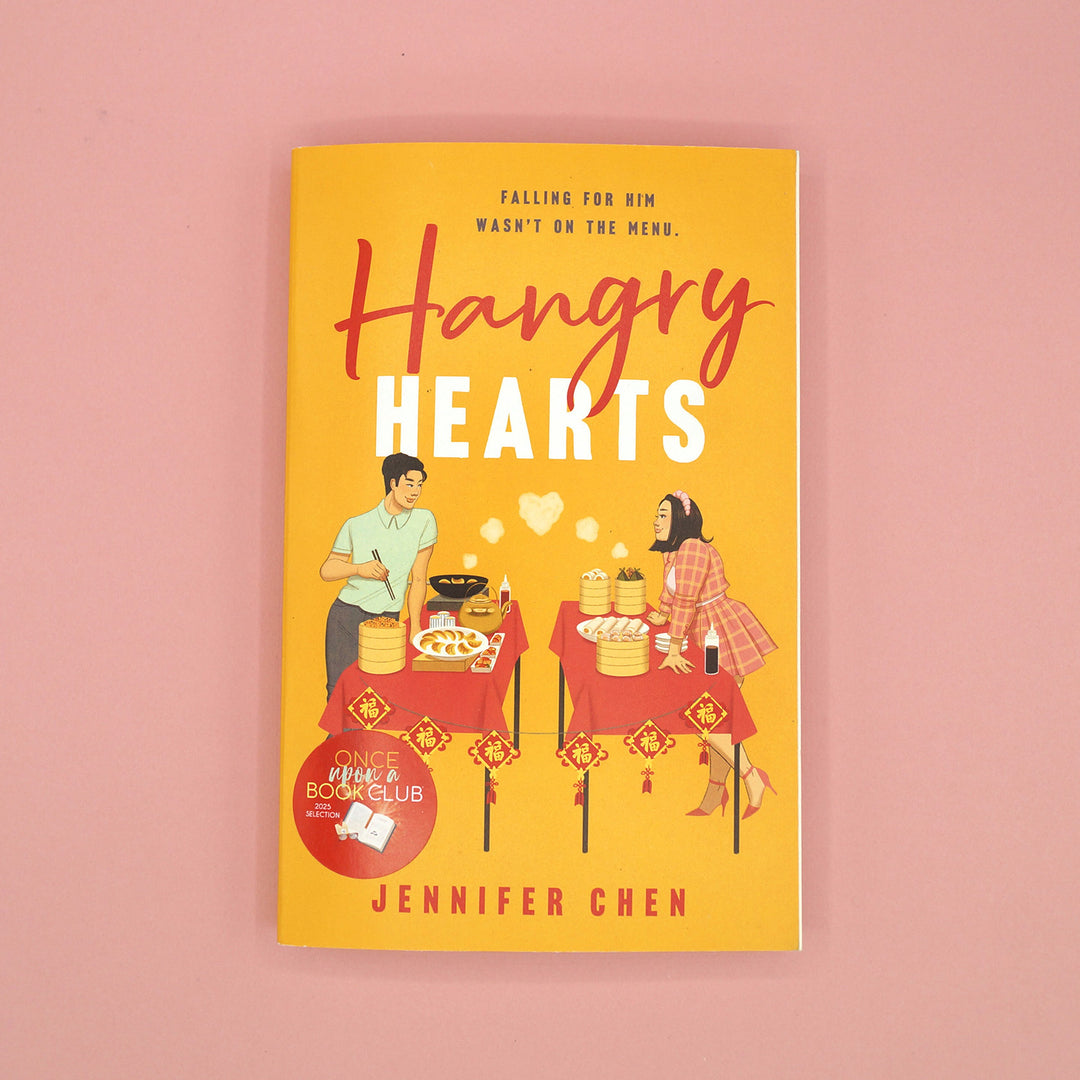 a paperback copy of "Hangry Hearts" by Jennifer Chen on a pink background.