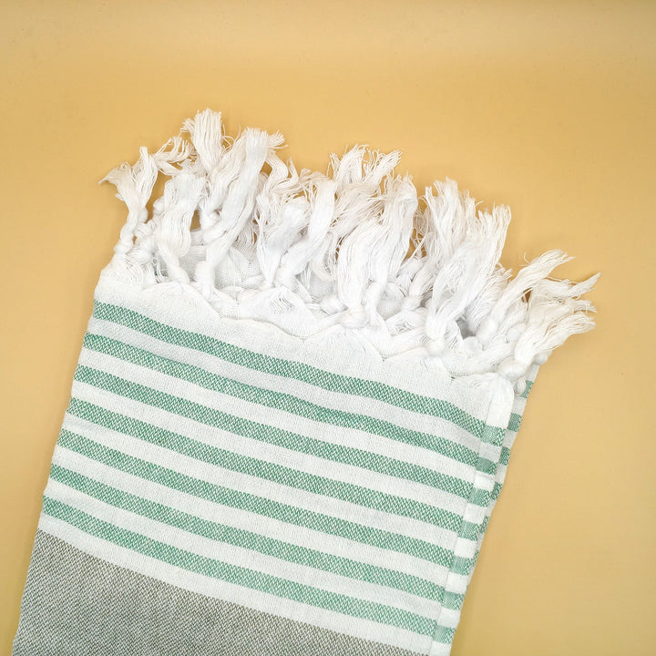 a seafoam green and gray striped beach towel