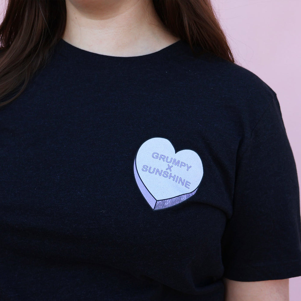 Black t-shirt with a purple heart-shaped candy design and 'Grumpy x Sunshine' text on a pink background.