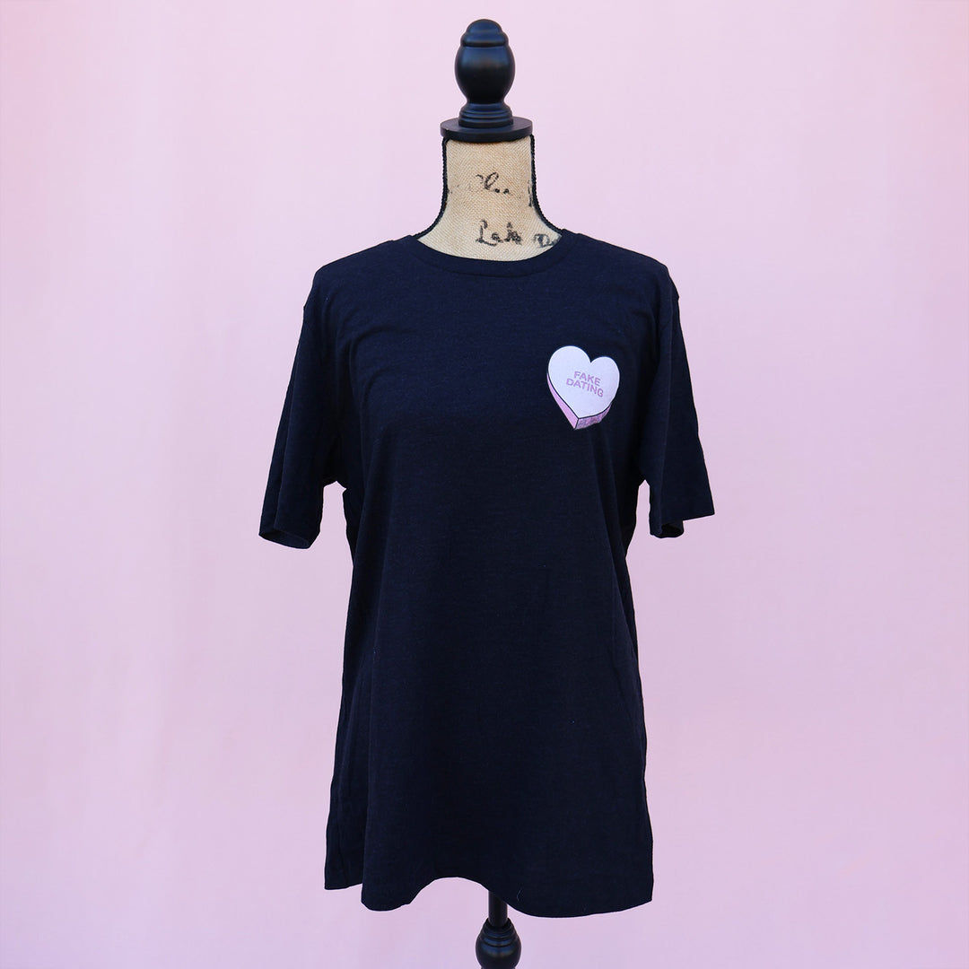 Black t-shirt with a pink heart-shaped candy design and 'FAKE DATING' text on a pink background.