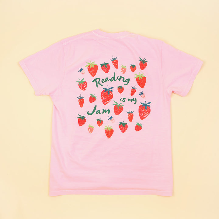 Pink t-shirt with strawberry design and 'Reading is my Jam' text on a beige background