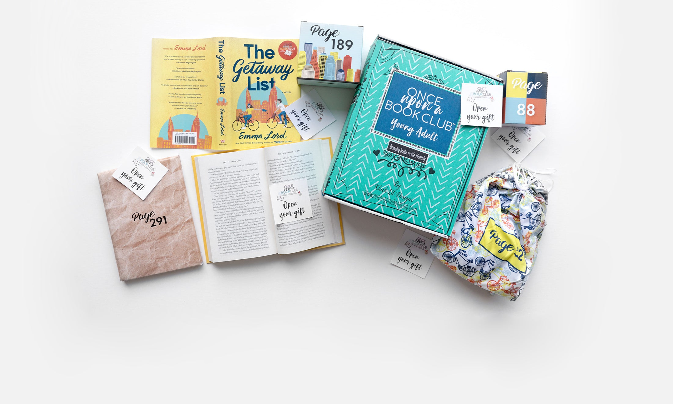 A green Once Upon a Book Club box sits next to an open book. The book has an 'open your gift' sticky note on the page. Wrapped gifts labeled with page numbers and many other open your gift sticky notes surround the open book emphasizing that you open the gifts as you read!