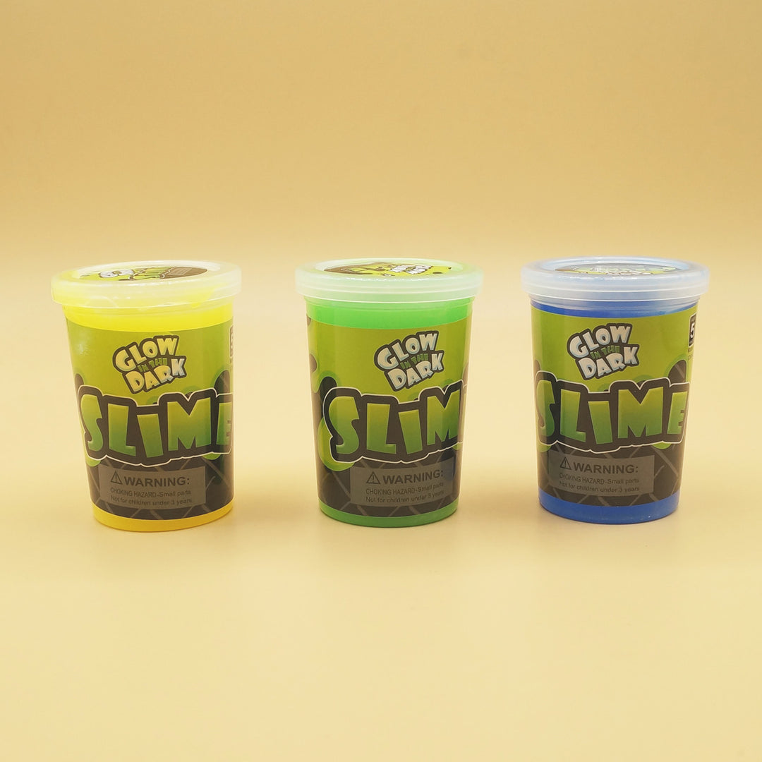 three containers of Glow in the Dark Slime in a line. From left to right they are yellow, green, and blue