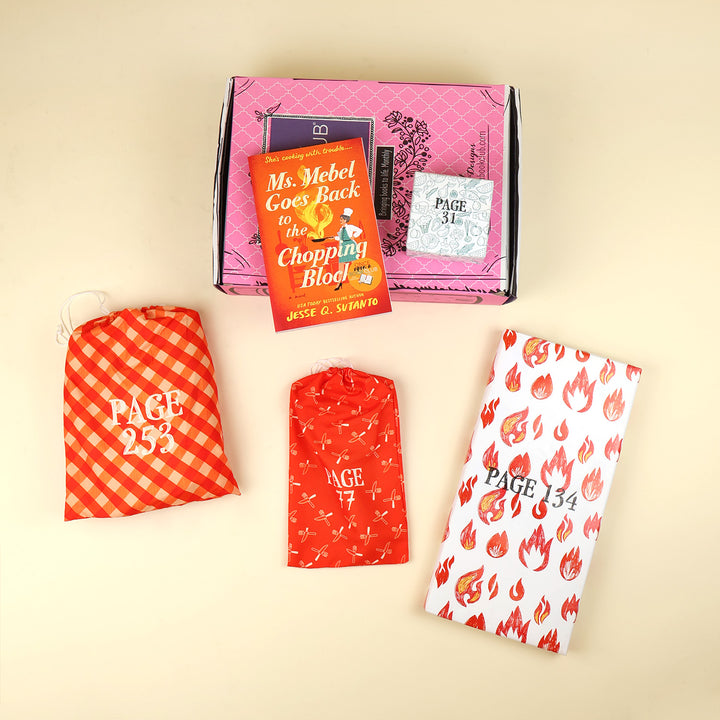 A new copy of Ms. Mebel Goes Back to the Chopping Block" by Jesse Q. Sutanto sits on a pink OUABC box. Also pictured are four wrapped gifts labeled with page numbers to open as you read!