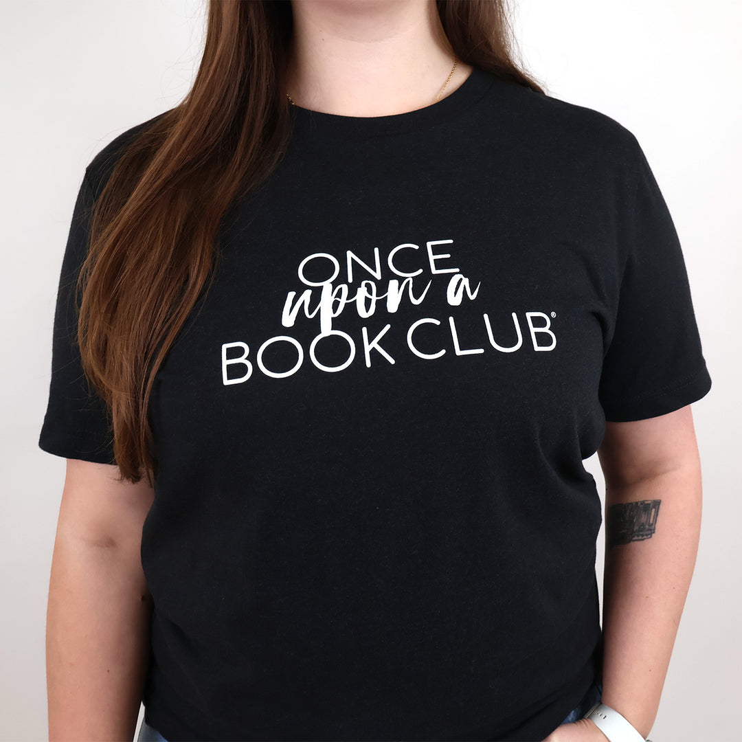 A woman wearing a black short-sleeve t-shirt with the white text 'Once Upon a Book Club' printed across the chest, shown against a plain light background.