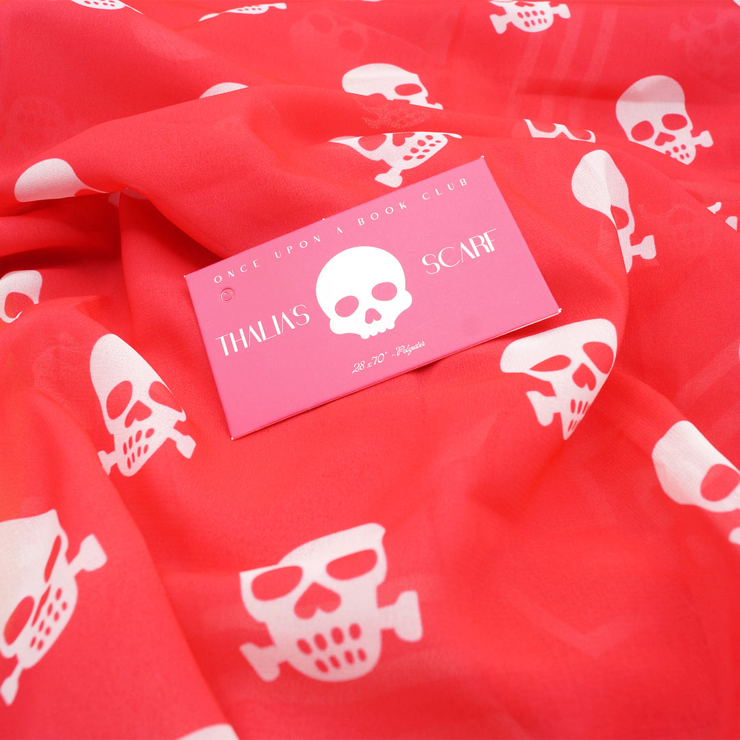 a hot pink scarf with white skulls on it