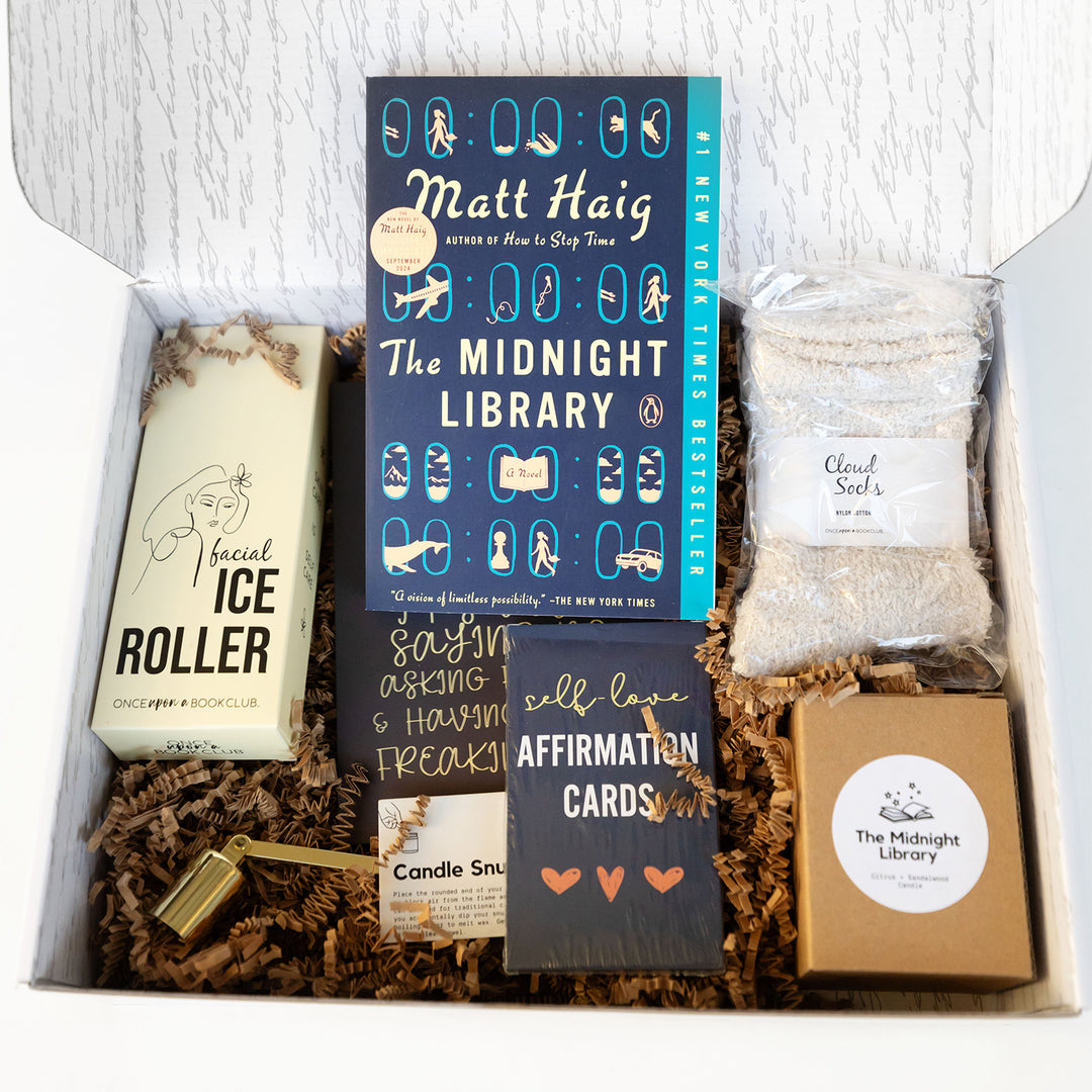 An open self-love box shows a copy of The Midnight Library and additional items.