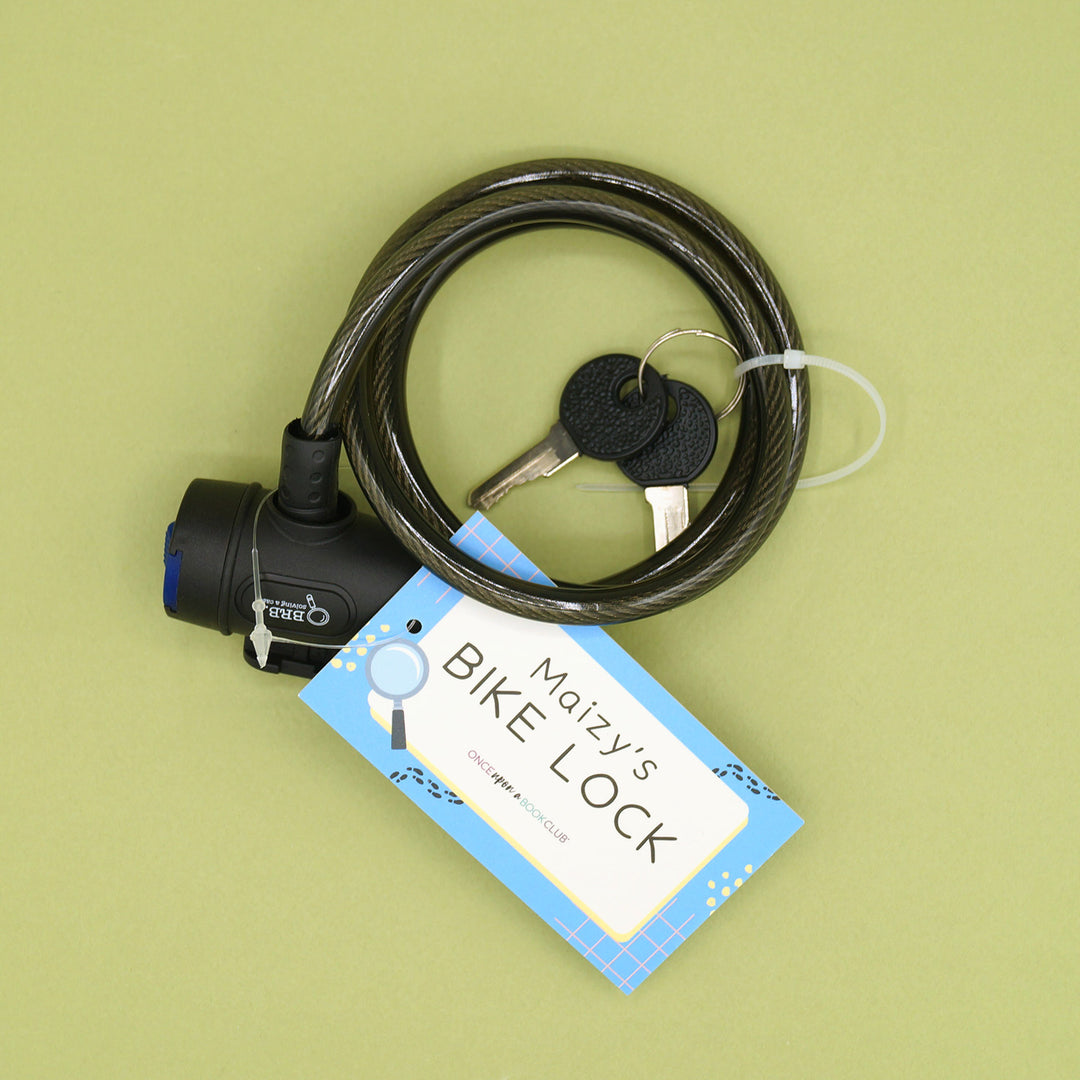 A black bike lock with two black keys attached to the cord. The card with the bike lock says Maizy's Bike Lock.