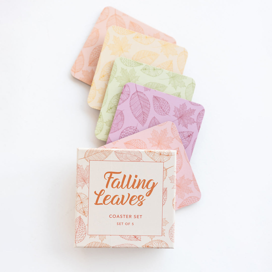 A box labeled Falling Leaves Coaster Set, Set of 5 with the five coasters laid out above the box. Each coaster has a pattern of leaves on it and is a different color: orange, yellow, green, purple, and red.
