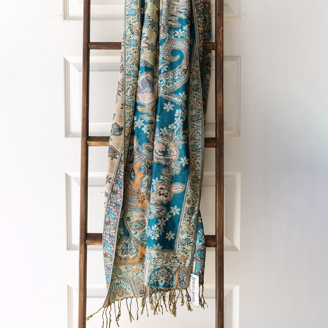 An oversized pashmina scarf in teal and beige colors.