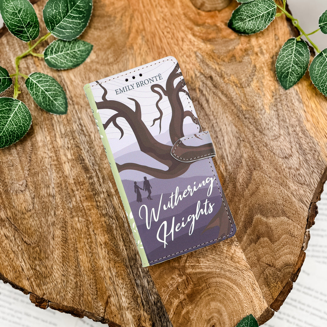 Phone case with 'Wuthering Heights' design on a wooden surface with leaves.