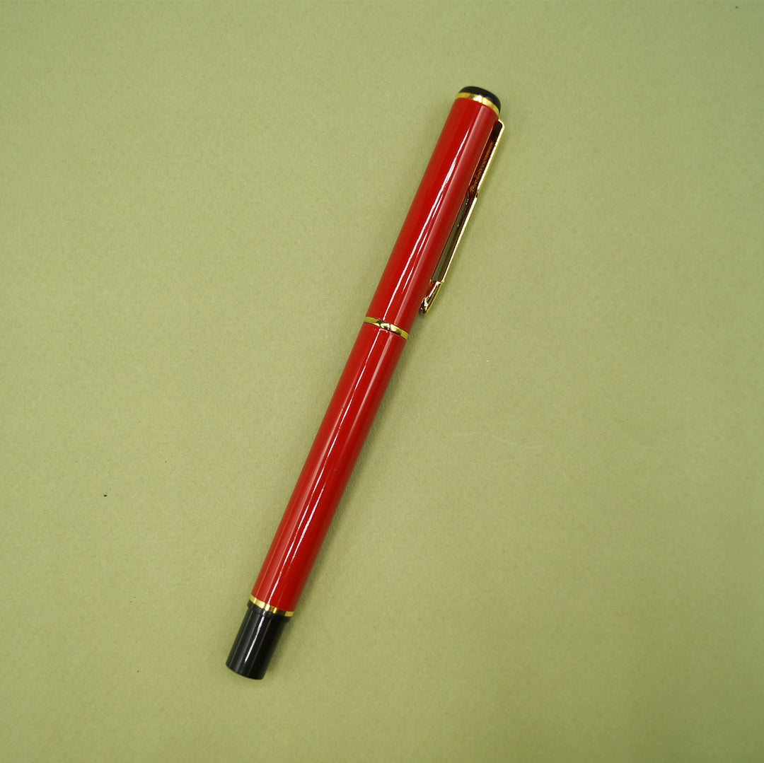 A bright red pen with a black bottom and gold accents.