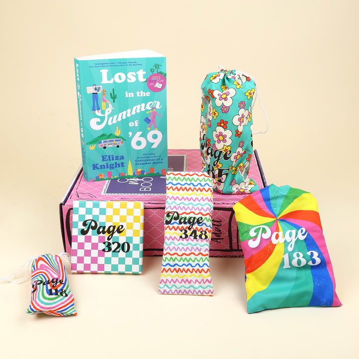 A new copy of Lost in the Summer of '69 by Eliza Knight sits on a pink OUABC box. Also pictured are five wrapped gifts labeled with page numbers to open as you read!