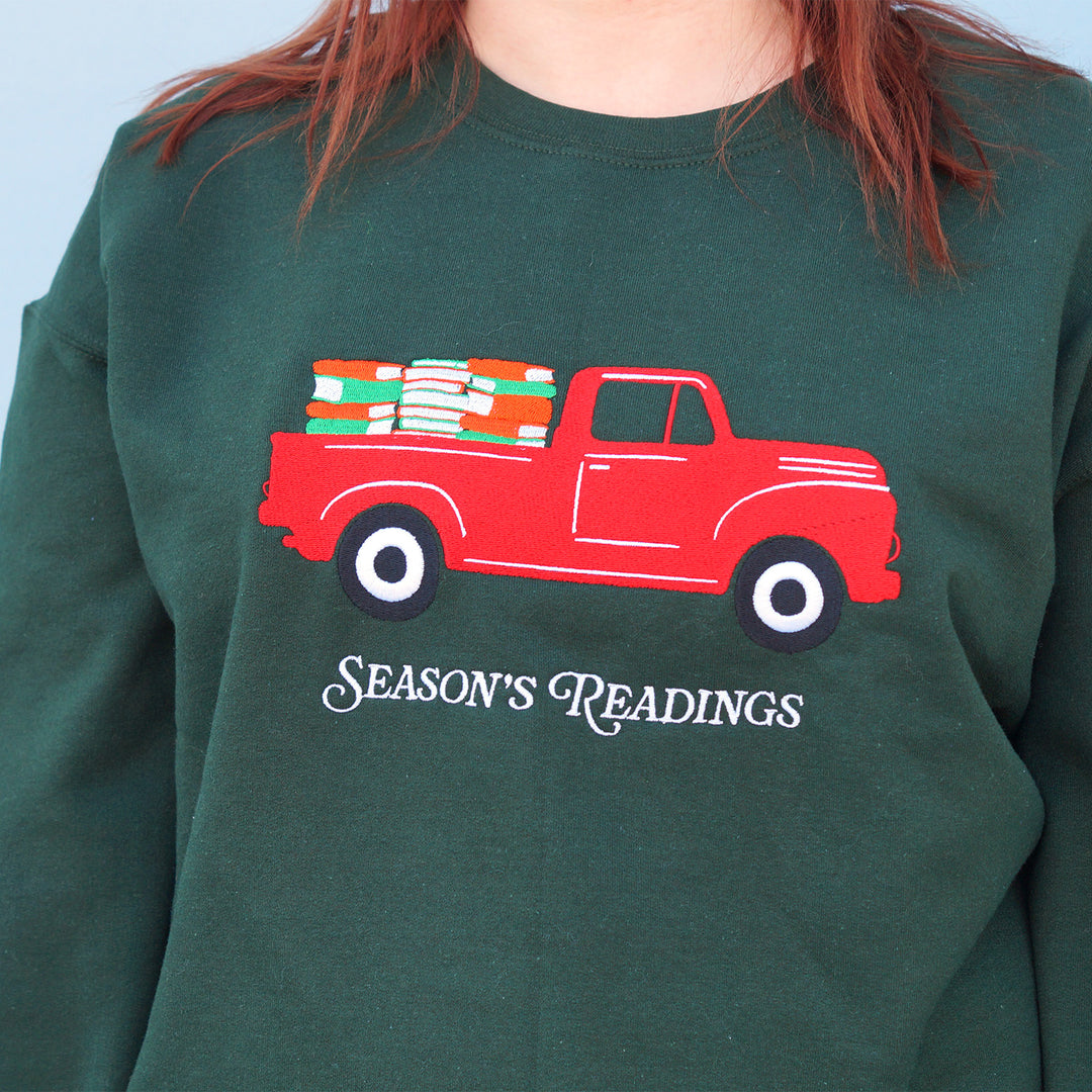 Green sweatshirt with a red truck and 'Season's Readings' text design.