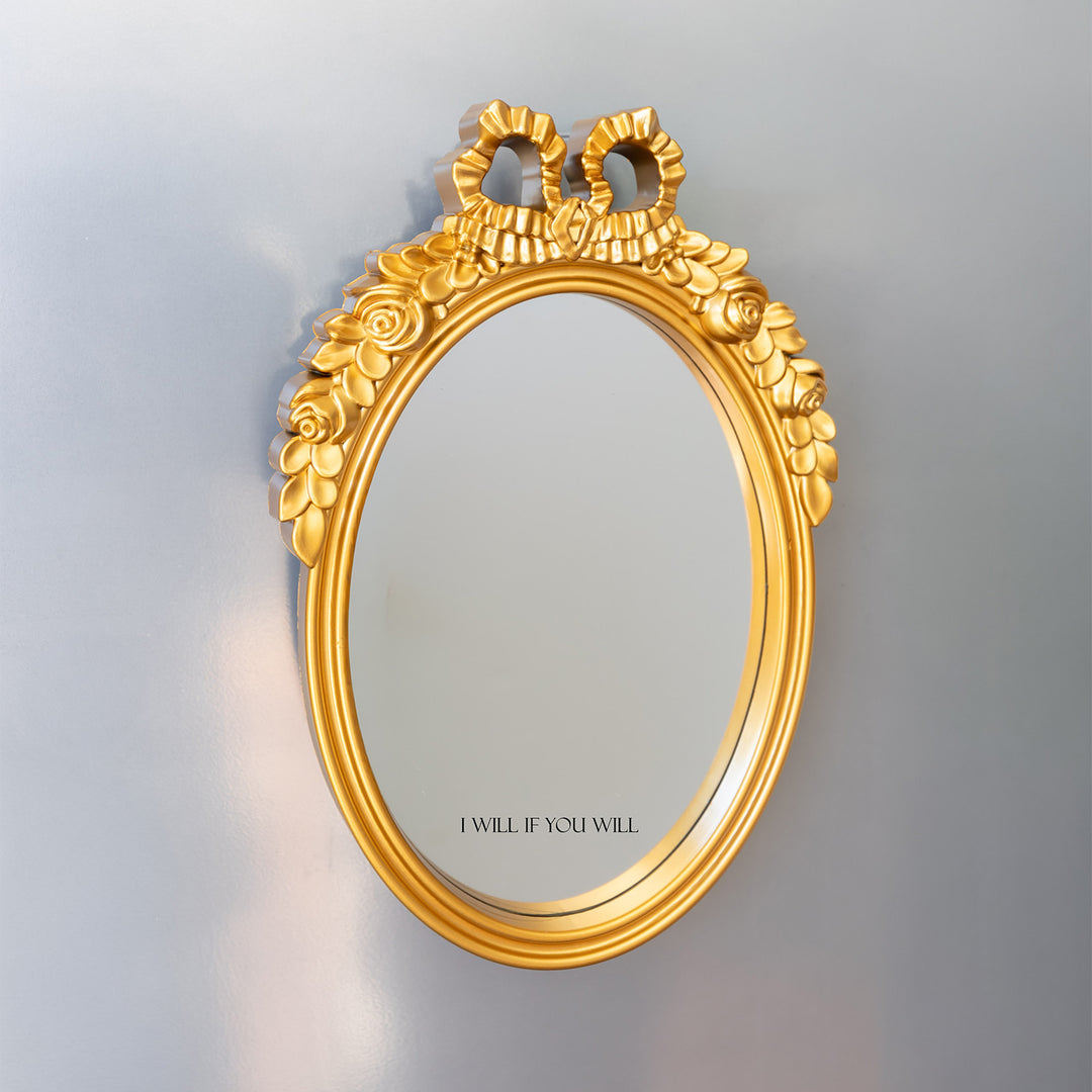 A bright gold mirror with black text at the bottom (on the mirror) that says I Will If You Will.