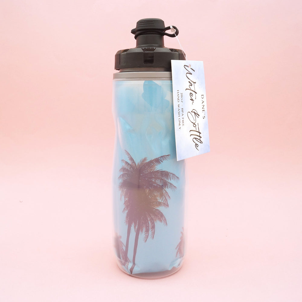 A double-lined water bottle with an image of a blue sky and palm trees on the inner line.
