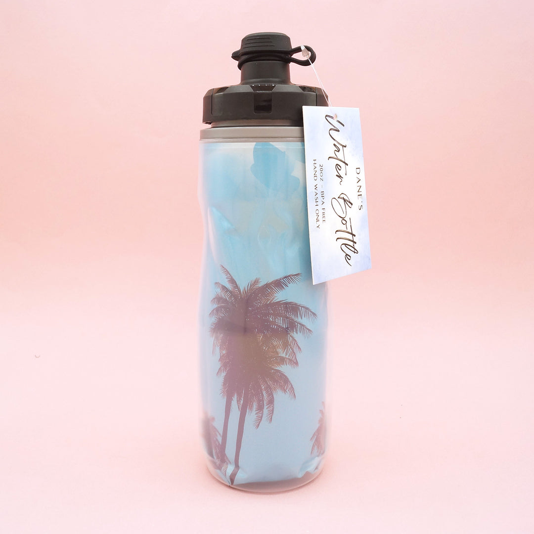A double-lined water bottle with an image of a blue sky and palm trees on the inner line.