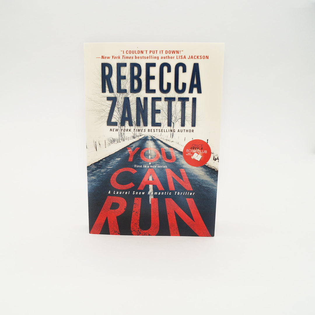 a mass market paperback copy of You Can Run by Rebecca Zanetti.