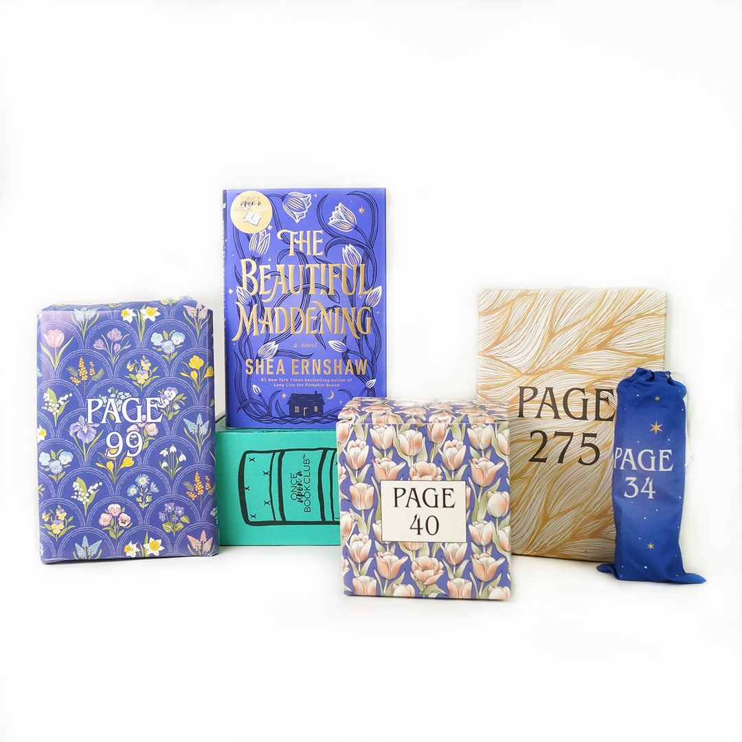 A hardcover edition of The Beautiful Maddening stands on a green OUABC box. In front of the box are four themed wrapped gifts labeled with page numbers.