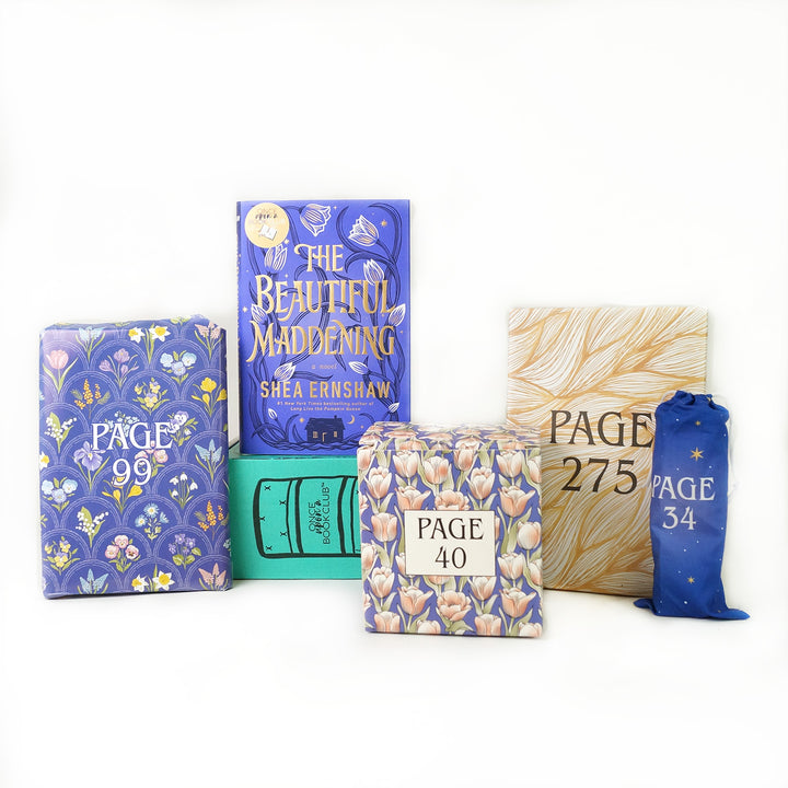 A hardcover edition of The Beautiful Maddening stands on a green OUABC box. In front of the box are four themed wrapped gifts labeled with page numbers.