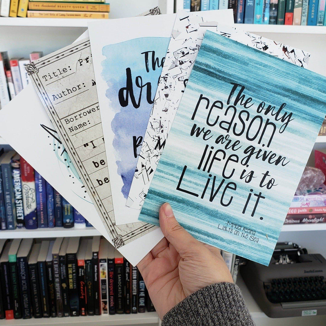 a white hand fans out a set of quote cards in front of a bookshelf