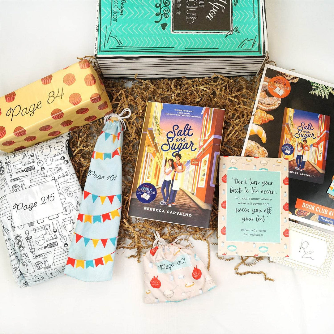 A green Once Upon a Book Club box is at the top of the image. In front of the box, from left to right, are a white polybag, yellow box with red polkadots, a light blue drawstring bag, hardcover edition of Salt and Sugar, white drawstring bag, quote card, bookclub kit, and signature card. The boxes and bags are labeled with page numbers.